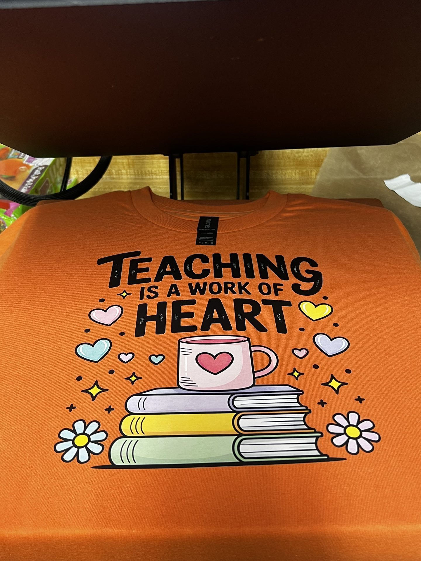 Custom orange tumbler with Teaching is a Work of Heart design and daisy details